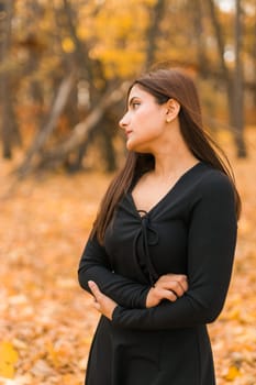 Close up portrait of pretty indian young woman enjoying warm autumn sunny day vacation outdoors. Generation z and gen z concept. Fall Season.