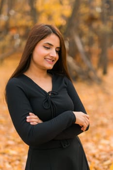 Close up portrait of pretty indian young woman enjoying warm autumn sunny day vacation outdoors. Generation z and gen z concept. Fall Season.