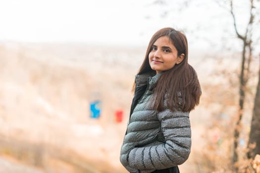 Close up portrait of pretty indian young woman enjoying warm autumn sunny day vacation outdoors. Generation z and gen z concept. Fall Season.