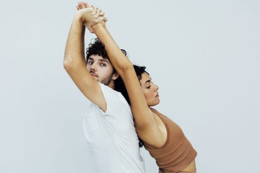 Yoga group concept. Young couple meditating together, sitting back to back on windows background