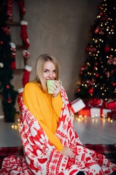 Woman drinking coffee at christmas tree