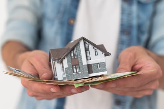 Real estate agent holding house model. High quality photo