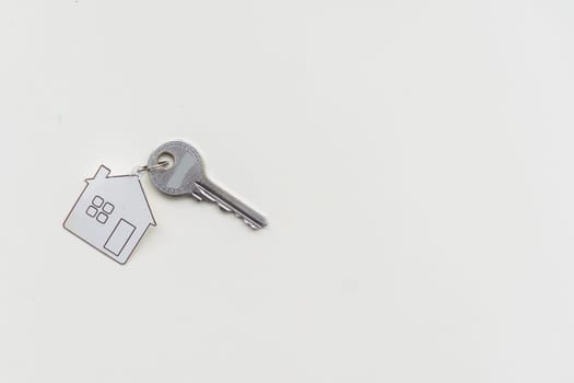 House keys with red house shaped keychain with hundred US dollars. High quality photo