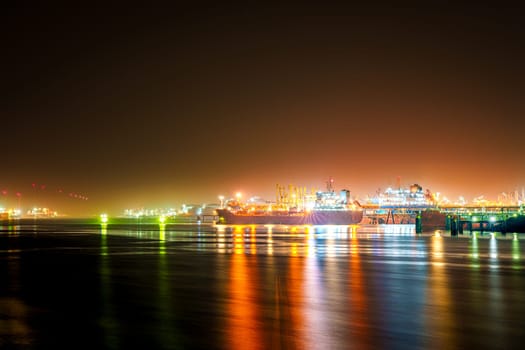 A captivating and surreal night shot of the Rotterdam port, shrouded in mystical mist, creating an enchanting and scenic atmosphere that evokes a sense of wonder and mystery.