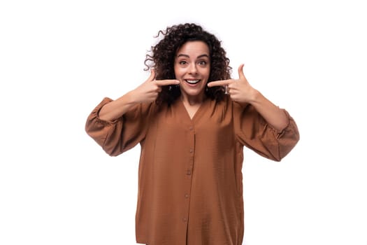 young curly leader woman in brown blouse smiling with open mouth.