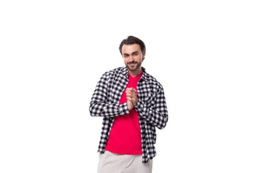 young handsome brunette man with a cool hairstyle and beard in a shirt on a white background with copy space.
