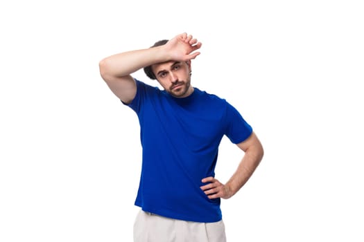 portrait of a young smart caucasian brunette man with a beard in a blue t-shirt thinking about business development. brainstorm.