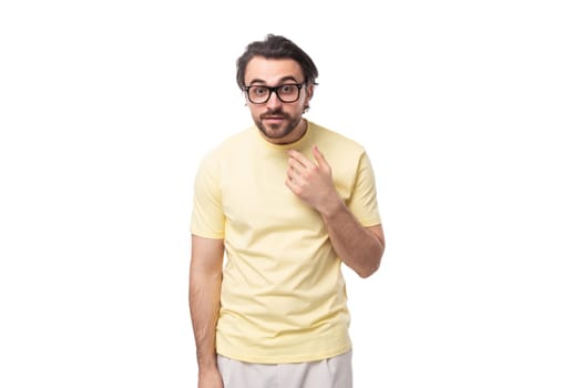 young caucasian man with black hair and beard wears eyeglasses.