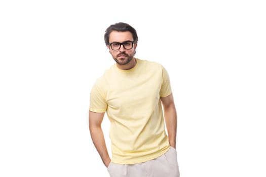 well-groomed young caucasian man with black hair and beard put on glasses for vision correction.