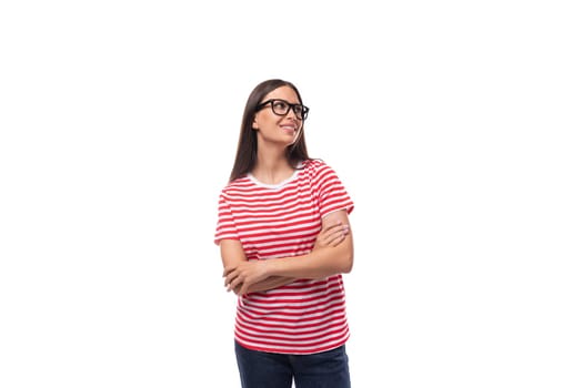 young charming brunette woman with glasses dressed in a striped t-shirt on a white background with copy space.