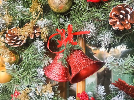 Christmas wreath with red and gold bauble decorations, bow, holly, mistletoe, pine cones and blue spruce fir over dark wood front door background.