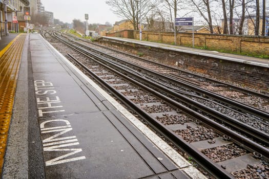 London, United Kingdom - February 01, 2019: Empty Rail tracks at Lewisham station on rainy day. Trains are used widely for public transport (along with Tube and Buses) in UK capital