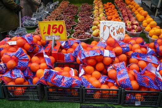 London, United Kingdom - February 04, 2019: Bags with oranges, and more fruits in bowls displayed on traditional fruit market at Lewisham.