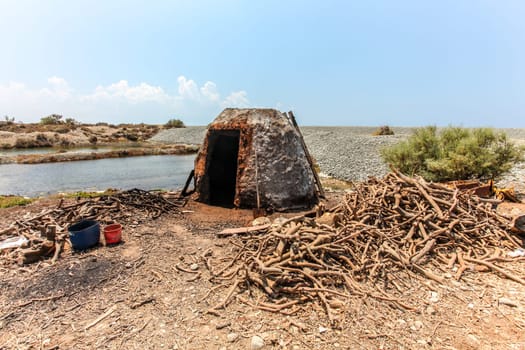 Small stone oven on the beach, used to burn tree roots for charcoal