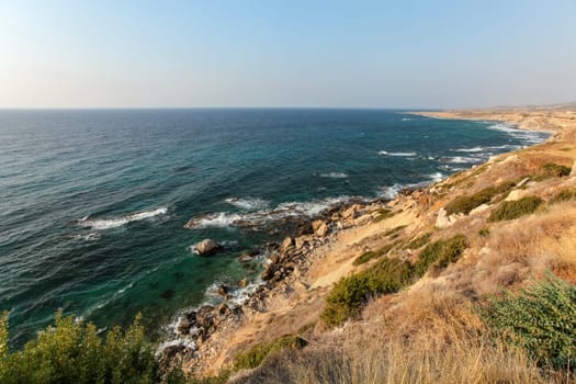 Evening sun shines on rough coast of Mediterranean Sea in Karpass region of Northern Cyprus