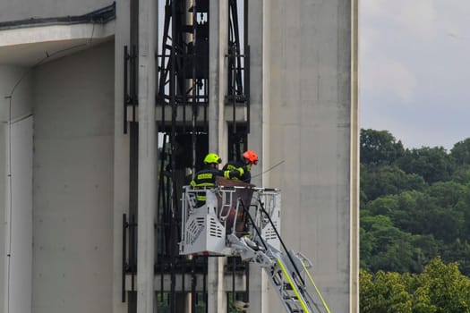 HUSTOPECE, CZECHIA - JULY 27, 2023: Firefighters at the church tower. Firefighter intervention at a high-rise building. Firefighters at the church tower. Firefighters at the church tower. Firefighter intervention at a high-rise building. Firefighters at a high-rise building fire.