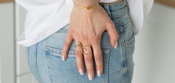 Women Jewelry concept. Woman's hands close up wearing rings and necklace modern accessories elegant lifestyle.