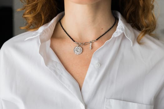 Female with silver pendant close-up. Image for e-commerce, online selling, social media, jewelry sale. Handmade jewelry.