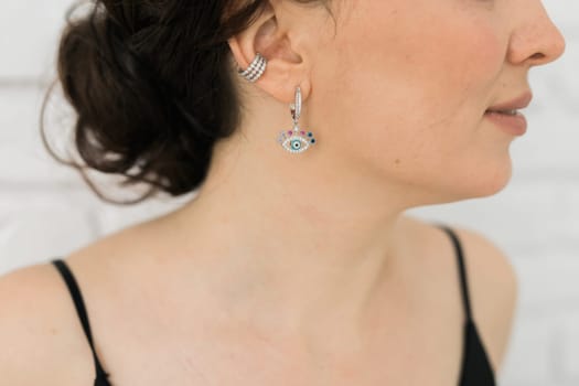 Detail of young woman wearing beautiful luxury earring. Handmade jewellery and accessories concept