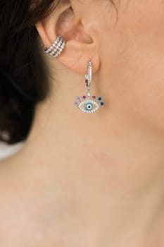 Detail of young woman wearing beautiful luxury earring. Handmade jewellery and accessories concept