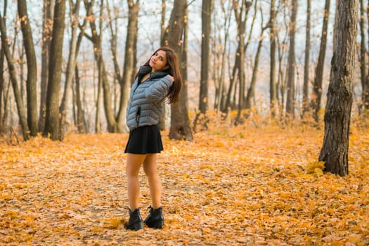 Close-up portrait of a young beautiful confident Indian Asian woman in fall outdoor. Happy and natural smiling female. Generation z and gen z youth