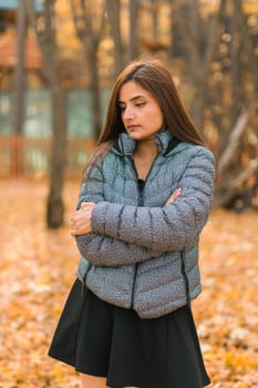 Beautiful indian woman generation z relaxing and feeling nature at autumn park in fall season. Diversity and gen z youth.