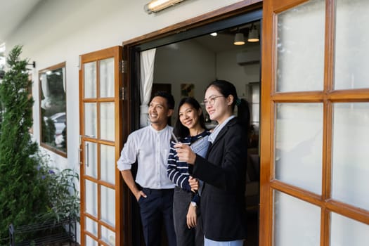 young couple with a real estate agent visiting home for buy or for rent.