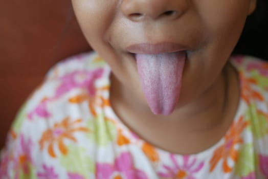 child shows his tongue closeup .