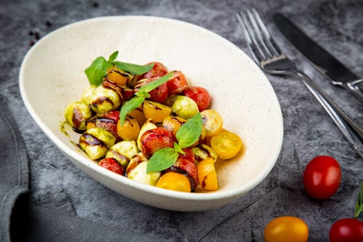 salad of yellow and red cherry tomatoes of different varieties with herbs