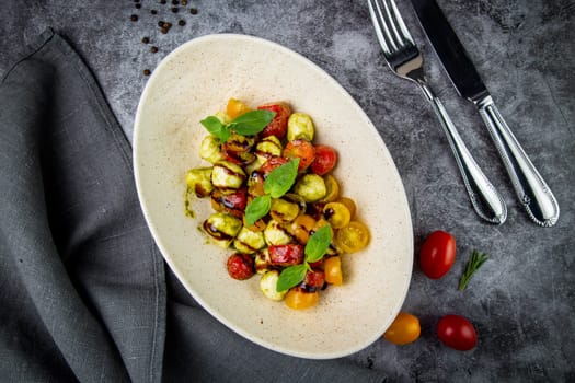 salad of yellow and red cherry tomatoes of different varieties with herbs