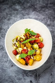 salad of yellow and red cherry tomatoes of different varieties with herbs