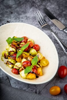 salad of yellow and red cherry tomatoes of different varieties with herbs