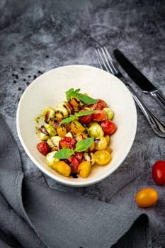 salad of yellow and red cherry tomatoes of different varieties with herbs