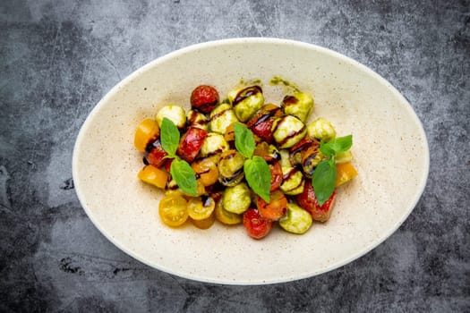 salad of yellow and red cherry tomatoes of different varieties with herbs