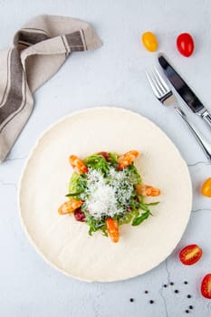 beautifully served shrimp with arugula and grated cheese