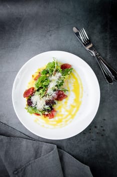 side view of salad with red fish, herbs and cheese