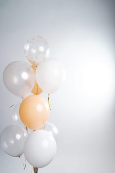 Balloons in white, beige and transparent colors on a gray background. High quality photo