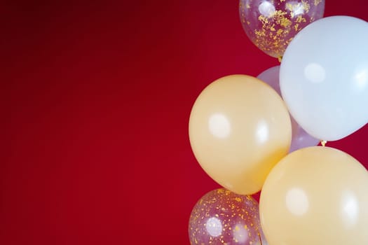 Light balloons - white, beige, transparent, pearl on a red background. Horizontal photo. Space for text. High quality photo