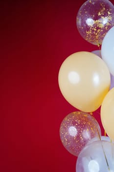 Vertical photo of white and transparent balloons on red burgundy background. Space for text. High quality photo