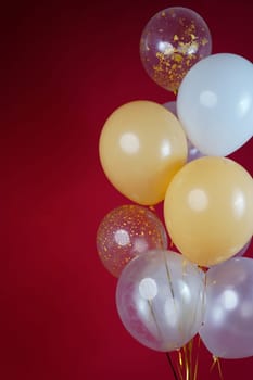 A bunch of light balloons on a red background. Vertical Photo Space for Text. High quality photo