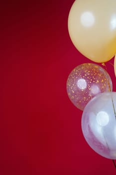 Vertical photo of white and transparent balloons on red burgundy background. Space for text. High quality photo