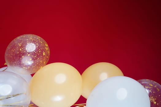 Vertical photo of white and transparent balloons on red burgundy background. Space for text. High quality photo