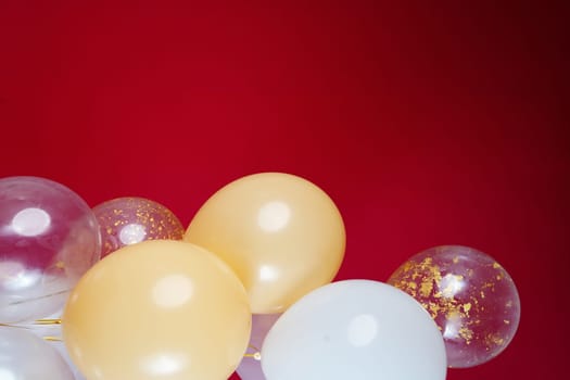 Vertical photo of white and transparent balloons on red burgundy background. Space for text. High quality photo