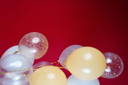 Vertical photo of white and transparent balloons on red burgundy background. Space for text. High quality photo