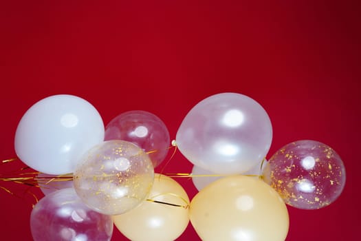 Vertical photo of white and transparent balloons on red burgundy background. Space for text. High quality photo