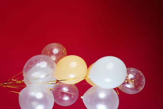 A bunch of light balloons on a red background. Vertical Photo Space for Text. High quality photo