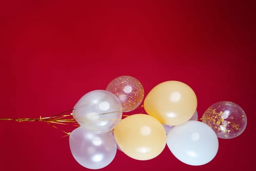 A bunch of light balloons on a red background. Vertical Photo Space for Text. High quality photo