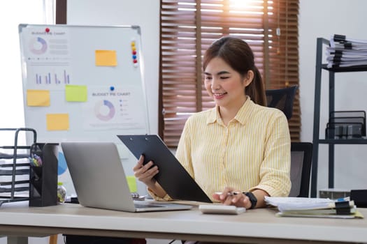 Businesswoman uses calculator to calculate finances, mathematics on table in office and business charts, tax, accounting, statistics and analytical research concept..