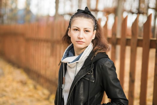 Outdoor atmospheric lifestyle portrait of young beautiful young woman copy space. Warm autumn fall season. Millennial generation and youth.