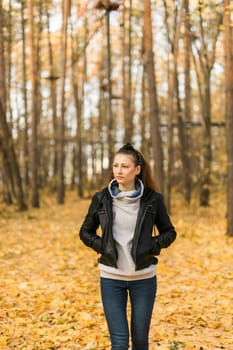 Outdoor atmospheric lifestyle portrait of young beautiful young woman copy space. Warm autumn fall season. Millennial generation and youth.